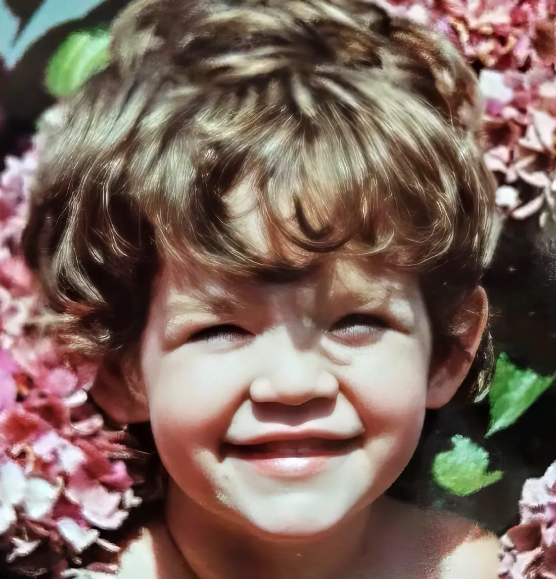 The same photograph after restoration, with the child's face and the blossom behind them in clear detail.